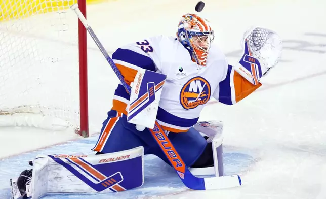 New York Islanders goalie David Rittich makes a save on a Calgary Flames shot during third period NHL hockey action in Calgary, Ab., Saturday, Jan. 17, 2026. (Larry MacDougal/The Canadian Press via AP)