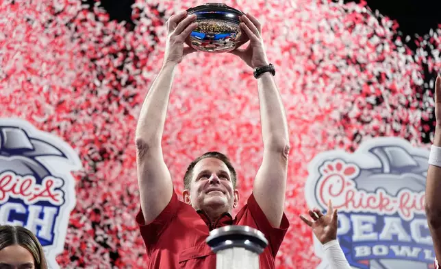 Indiana head coach Curt Cignetti holds up the trophy after the Peach Bowl NCAA college football playoff semifinal against Oregon, Friday, Jan. 9, 2026, in Atlanta. (AP Photo/Brynn Anderson)