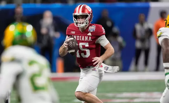 Indiana quarterback Fernando Mendoza (15) carries against Oregon during the first half of the Peach Bowl NCAA college football playoff semifinal, Friday, Jan. 9, 2026, in Atlanta. (AP Photo/Mike Stewart)