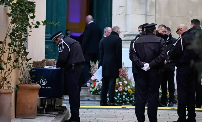 A police officer signs the condolence book outside Notre-Dame de l'Assomption church before Brigitte Bardot's funeral ceremony, Wednesday, Jan. 7, 2026 in Saint-Tropez, southern France. (AP Photo/Philippe Magoni)