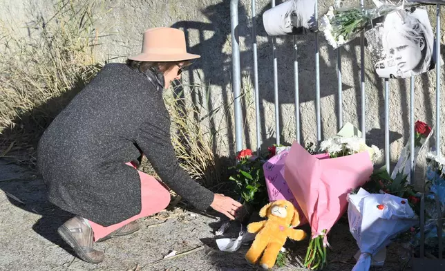 A woman lays flowers at actor Brigitte Bardot's home in Saint-Tropez, southern France, Sunday, Dec. 28, 2025 after the French 1960s sex symbol who became one of the greatest screen sirens of the 20th century and later a militant animal rights activist and far-right supporter, has died. She was 91. (AP Photo/Philippe Magoni)