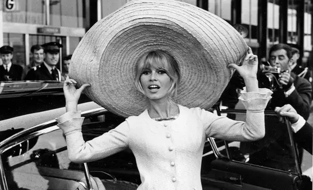 FILE - French actress Brigitte Bardot poses with a huge sombrero she brought back from Mexico, as she arrives at Orly Airport in Paris, France, on May 27, 1965. (AP Photo/File)