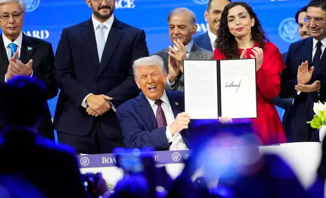 President Donald Trump holds the charter during a signing ceremony on his Board of Peace initiative at the Annual Meeting of the World Economic Forum in Davos, Switzerland, Thursday, Jan. 22, 2026. (AP Photo/Markus Schreiber)