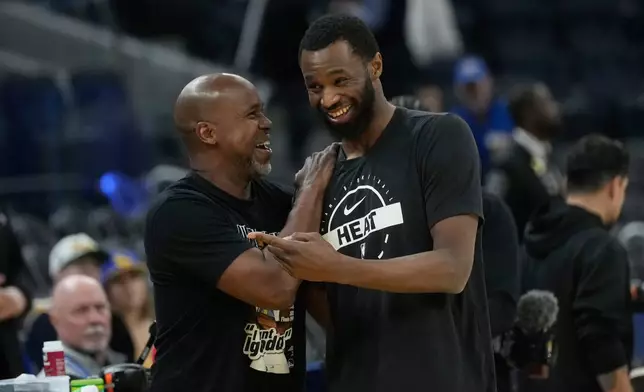 Golden State Warriors assistant coach Kris Weems, left, talks with Miami Heat forward Andrew Wiggins before an NBA basketball game in San Francisco, Monday, Jan. 19, 2026. (AP Photo/Jeff Chiu)