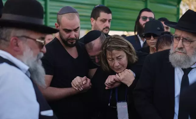 Annie, center, is comforted during the funeral of her son Dan Elkayam, a young French Jewish man who was killed in the mass shooting that targeted a Hanukkah celebration on Sydney's Bondi Beach in Australia, in Ashdod, Israel, Thursday, Dec. 25, 2025. (AP Photo/Ariel Schalit)