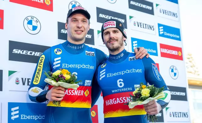 Juri Thomas Gatt, left, and Riccardo Schöpf of Austria celebrate their third place in the doubles men competition of the Luge World Cup in Winterberg, Germany, Sunday Jan. 11, 2026. (David Inderlied/dpa via AP)
