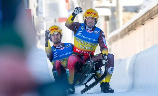 Tobias Wendl and Tobias Arlt of Germany celebrate their victory in the doubles men competition of the Luge World Cup in Winterberg, Germany, Sunday Jan. 11, 2026. (David Inderlied/dpa via AP)
