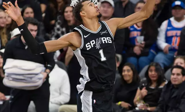 San Antonio Spurs center Victor Wembanyama (1) blocks a shot during the first half of an NBA basketball game against the New York Knicks, Wednesday, Dec. 31, 2025, in San Antonio. (AP Photo/Darren Abate)