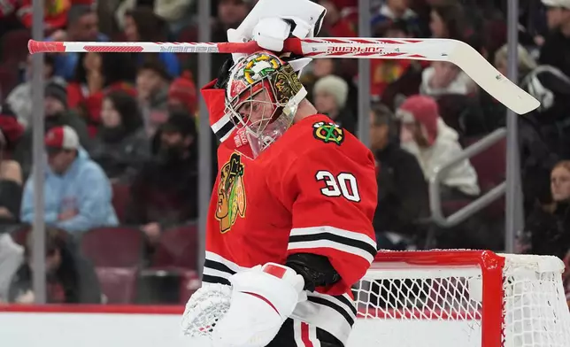 Chicago Blackhawks goaltender Spencer Knight adjusts his helmet during the first period of an NHL hockey game against the Dallas Stars in Chicago, Thursday, Jan. 1, 2026. (AP Photo/Nam Y. Huh)
