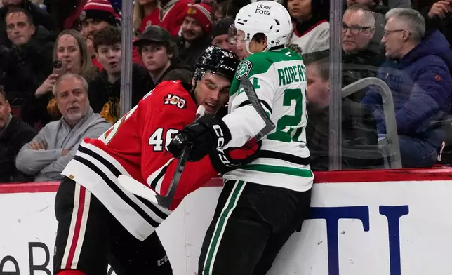 Dallas Stars left wing Jason Robertson, right, is checked by Chicago Blackhawks defenseman Louis Crevier during the first period of an NHL hockey game in Chicago, Thursday, Jan. 1, 2026. (AP Photo/Nam Y. Huh)