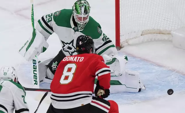 Dallas Stars goaltender Jake Oettinger, top, saves a shot by Chicago Blackhawks center Ryan Donato during the second period of an NHL hockey game in Chicago, Thursday, Jan. 1, 2026. (AP Photo/Nam Y. Huh)