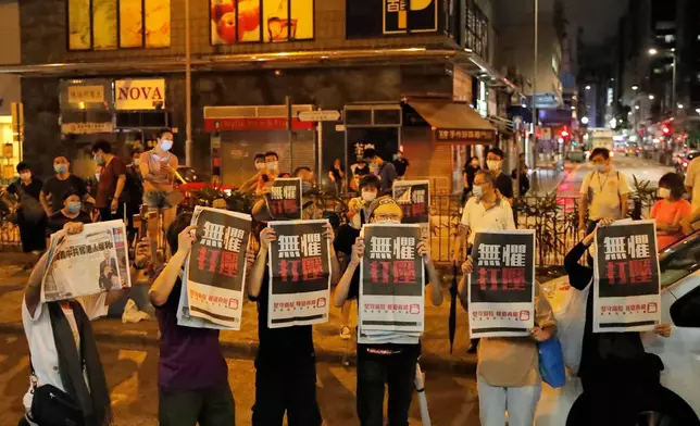 FILE -Supporters of Hong Kong media tycoon Jimmy Lai hold the copies of Apple Daily newspaper as Lai leaves a police station after being bailed out in Hong Kong, Wednesday, Aug. 12, 2020. (AP Photo/Kin Cheung, File)