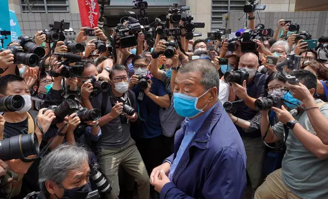 FILE - Hong Kong media tycoon Jimmy Lai, center, wearing a face mask arrives at court for charges relating to unlawful protests in Hong Kong, May 18, 2020. (AP Photo/Vincent Yu, File)