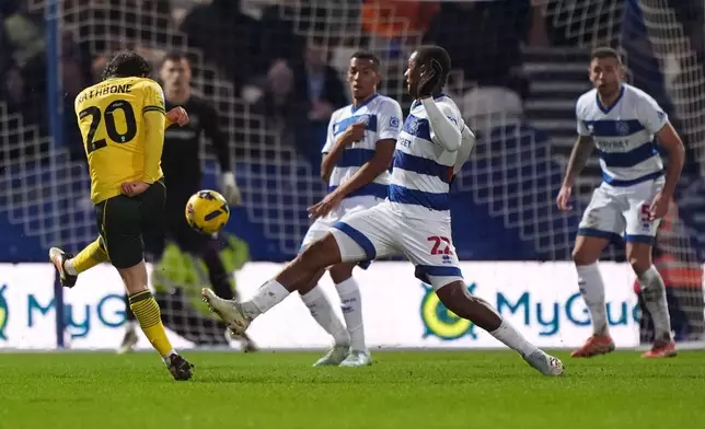 Wrexham's Ollie Rathbone, left, scores their side's third goal of the game during the Sky Bet Championship soccer match between Queens Park Rangers and Wrexham in London, Saturday Jan. 24, 2026. (Ben Whitley/PA via AP)