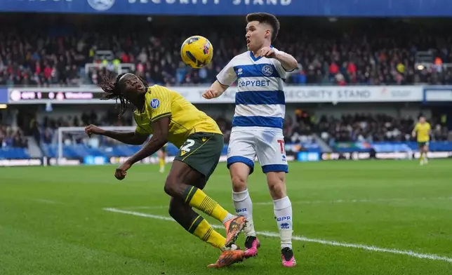 Wrexham's Issa Kabore, left, and Queens Park Rangers' Paul Smyth battle for the ball during the Sky Bet Championship soccer match between Queens Park Rangers and Wrexham in London, Saturday Jan. 24, 2026. (Ben Whitley/PA via AP)