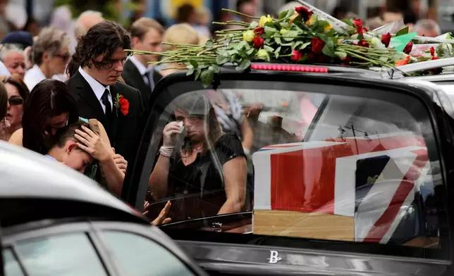 FILE - Mourners react as funeral hearses drive the coffins of four British soldiers through the town of Wootton Bassett in England, Thursday, July 22, 2010, after their bodies were repatriated to the UK after they were killed in Afghanistan. (AP Photo/Matt Dunham, file)