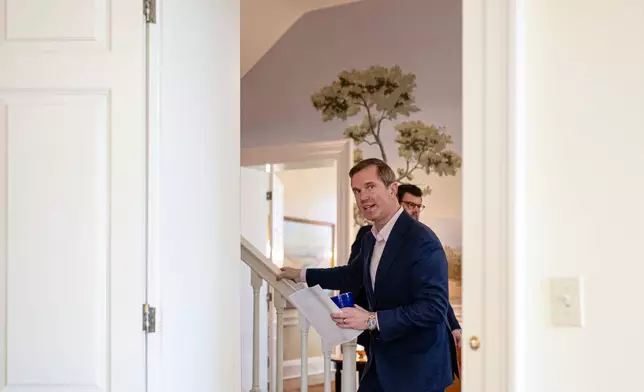 Kentucky Gov. Andy Beshear walks past his office before giving an interview, Monday, Jan. 12, 2026, in Frankfort, Ky. (AP Photo/Jon Cherry)
