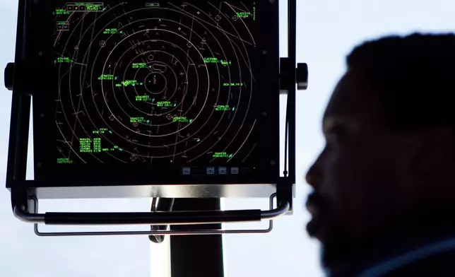 FILE - In this Sept. 18, 2008, file photo an air traffic controller stands beneath a radar screen in the control tower at Washington's Reagan National Airport. (AP Photo/Charles Dharapak, File)