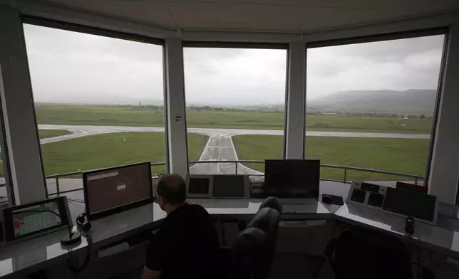 FILE - In this Friday, May 11, 2018 photo, a man watches a screen atop the air-traffic control tower at the empty Stepanakert airport. (AP Photo/Thanassis Stavrakis, File)