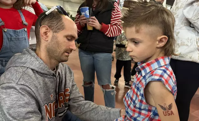 Billy Jenkins, left, gets his 6-year-old son Axell Jenkins ready for a mullet hairstyle contest, Monday, Jan. 12, 2026 in Harrisburg, Pa. (AP Photo/Tassanee Vejpongsa)