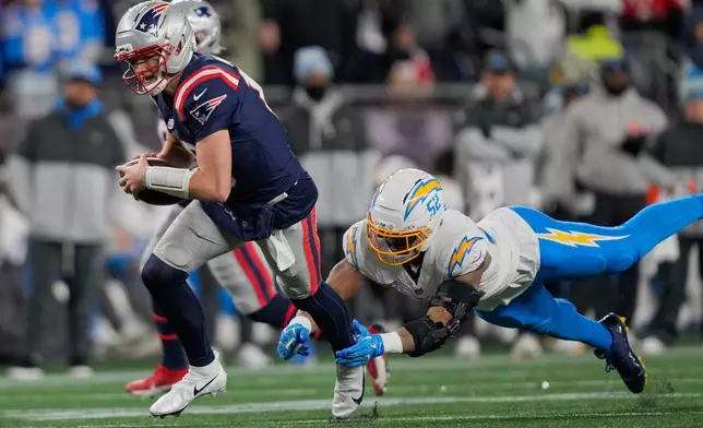 New England Patriots quarterback Drake Maye, left, avoids a tackle by Los Angeles Chargers linebacker Khalil Mack (52) in the second half of an NFL wild-card playoff football game in Foxborough, Mass., Sunday, Jan. 11, 2026. (AP Photo/Charles Krupa)