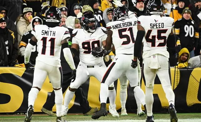 Houston Texans defensive tackle Sheldon Rankins (90) celebrates with cornerback Tremon Smith (11), defensive end Will Anderson Jr. (51) and linebacker E.J. Speed (45) after a touchdown during the second half of an NFL wild-card playoff football game against the Pittsburgh Steelers, Monday, Jan. 12, 2026, in Pittsburgh. (AP Photo/Justin Berl)