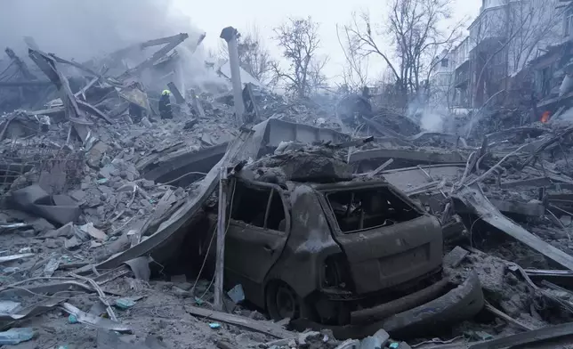 Emergency services personnel work to extinguish a fire following a Russian missile attack in Kharkiv, Ukraine, Friday, Jan. 2, 2026. (AP Photo/Andrii Marienko)