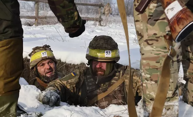 In this photo provided by Ukraine's 65th Mechanized Brigade press service, recruits perform drills at a training ground in the Zaporizhzhia region, Ukraine, Thursday, Jan. 1, 2026. (Andriy Andriyenko/Ukraine's 65th Mechanized Brigade via AP)