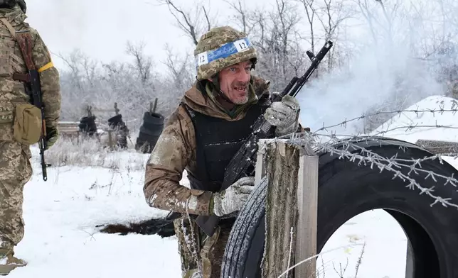In this photo provided by Ukraine's 65th Mechanized Brigade press service, recruits perform drills at a training ground in the Zaporizhzhia region, Ukraine, Thursday, Jan. 1, 2026. (Andriy Andriyenko/Ukraine's 65th Mechanized Brigade via AP)