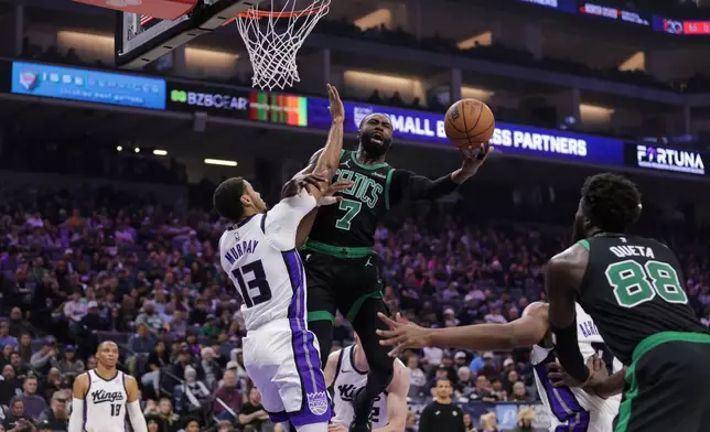 Boston Celtics guard Jaylen Brown (7) attempts a layup over Sacramento Kings forward Keegan Murray (13) during the first half of an NBA basketball game Thursday, Jan. 1, 2026, in Sacramento, Calif. (AP Photo/Scott Marshall)