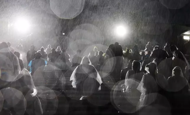 FILE - Rain comes down on attendees at the 137th Rose Parade Thursday, Jan. 1, 2026, in Pasadena, Calif. (AP Photo/Caroline Brehman, File)