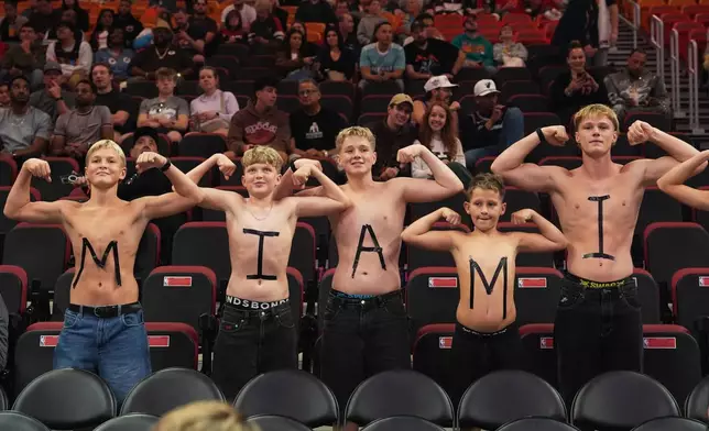FILE - Fans pose for a photo before an NBA basketball game between the Miami Heat and the Indiana Pacers, Dec. 27, 2025, in Miami. (AP Photo/Lynne Sladky, File