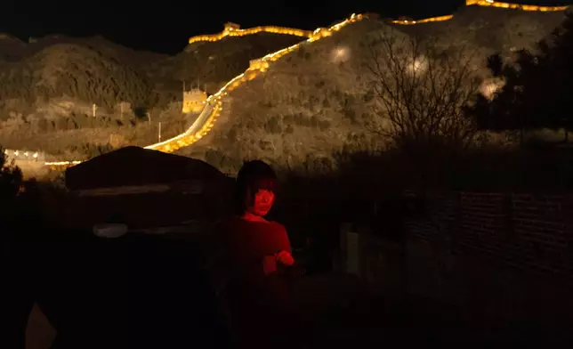 FILE - A woman stands for a photo by her friend before an event to ring in the new year at the Juyongguan Great Wall on the outskirts of Beijing, Dec. 31, 2025. (AP Photo/Ng Han Guan, File)