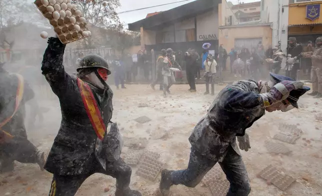 FILE - Revelers take part in the Els Enfarinats festival, a battle using flour, eggs and firecrackers, in the town of Ibi near Alicante, Spain, Dec. 28, 2025. (AP Photo/Alberto Saiz File)