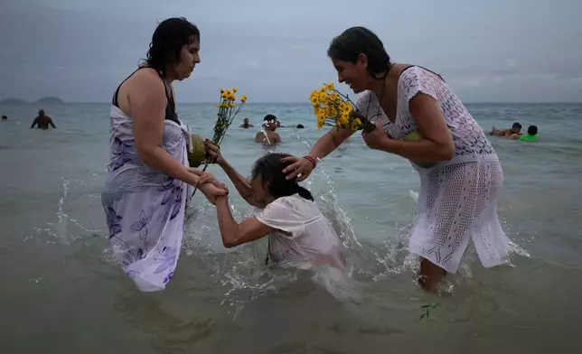 FILE - People pray on Copacabana Beach during a ceremony honoring Yemanja, the sea goddess of the Yoruba religion, a New Year's tradition in Rio de Janeiro, Brazil, Dec. 29, 2025. (AP Photo/Bruna Prado, File)