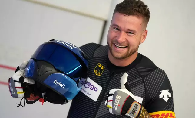 FILE - Second placed Johannes Lochner of Germany celebrates after the men's two-man bobsleigh World Cup race in Igls, near Innsbruck, Austria, Saturday, Nov. 20, 2021. (AP Photo/Matthias Schrader, FILE)