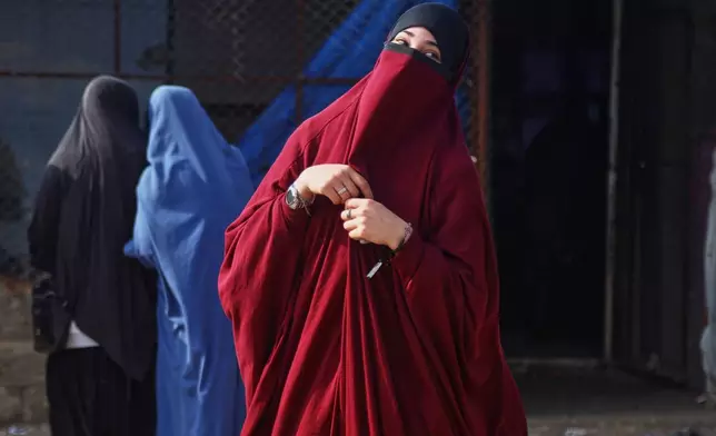 Women wait to enter a building supplying food and other goods at Roj camp, one of the detention facilities holding thousands of Islamic State group members and their families, in the al-Malikiyah area of northeastern Syria, Thursday, Jan. 29, 2026. (AP Photo/Baderkhan Ahmad)