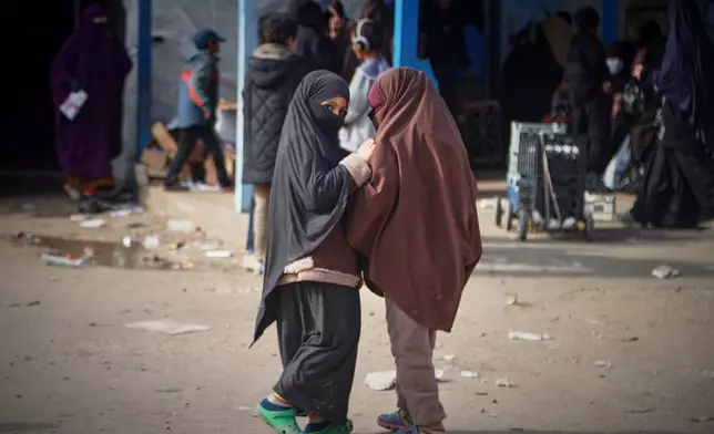 Two girls stand at Roj camp, one of the detention facilities holding thousands of Islamic State group members and their families, in the al-Malikiyah area of northeastern Syria, Thursday, Jan. 29, 2026. (AP Photo/Baderkhan Ahmad)
