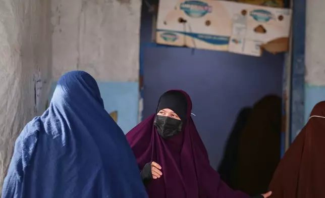 Women wait to enter a building supplying food and other goods at Roj camp, one of the detention facilities holding thousands of Islamic State group members and their families, in the al-Malikiyah area of northeastern Syria, Thursday, Jan. 29, 2026. (AP Photo/Baderkhan Ahmad)