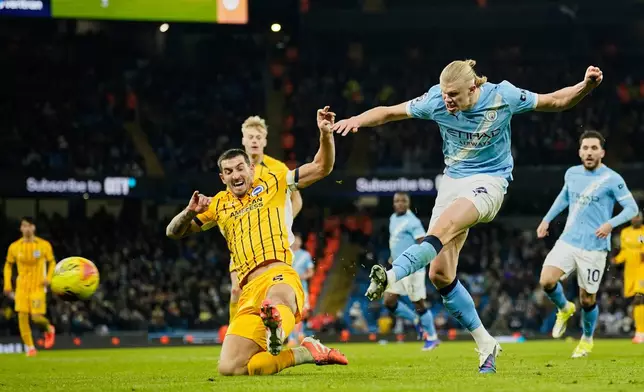 Manchester City's Erling Haaland, right, attempts a shot at goal in front of Brighton's Lewis Dunk during the English Premier League soccer match between Manchester City and Brighton and Hove Albion in Manchester, England, Wednesday, Jan. 7, 2026. (AP Photo/Dave Thompson)