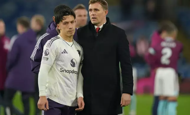 Manchester United's interim manager Darren Fletcher and Lisandro Martinez walk off the pitch after the Premier League soccer match between Burnley and Manchester United in Burnley, England Wednesday, Jan. 7, 2026. (AP Photo/Ian Hodgson)