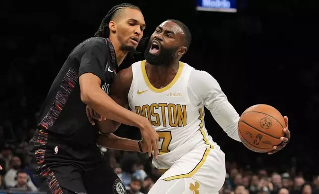Brooklyn Nets' Ziaire Williams, left, defends Boston Celtics' Jaylen Brown during the second half of an NBA basketball game Friday, Jan. 23, 2026, in New York. (AP Photo/Frank Franklin II)