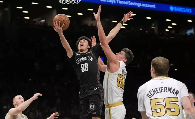 Brooklyn Nets' Nolan Traore (88) drives past Boston Celtics' Luka Garza (52) during the first half of an NBA basketball game Friday, Jan. 23, 2026, in New York. (AP Photo/Frank Franklin II)