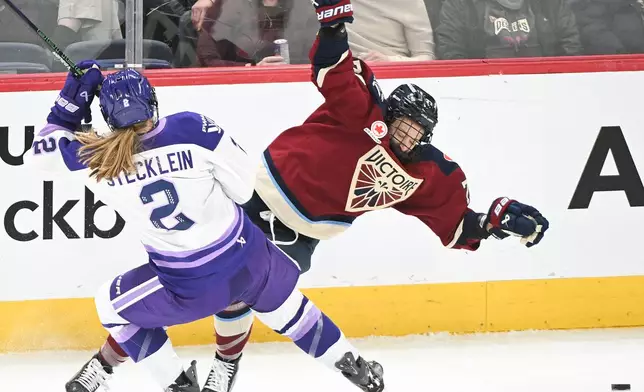 Minnesota Frost's Lee Stecklein (2) collides with Montreal Victoire's Jade Downie-Landry, right, during first-period PWHL hockey game action in Laval, Quebec, Sunday, Jan. 4, 2026. (Graham Hughes/The Canadian Press via AP)