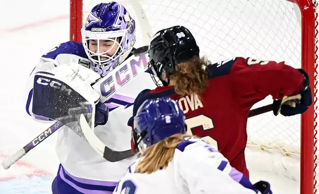 Minnesota Frost goaltender Maddie Rooney, left, swats the puck away from Montreal Victoire's Natalie Mlynkova (96) during second-period PWHL hockey game action in Laval, Quebec, Sunday, Jan. 4, 2026. (Graham Hughes/The Canadian Press via AP)