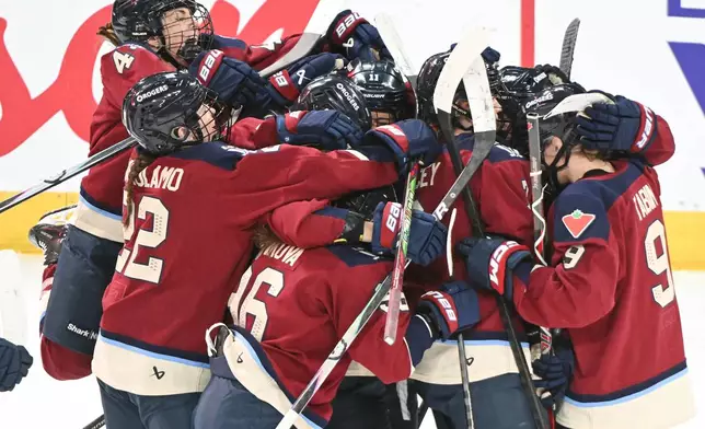 Montreal Victoire players celebrate a goal by teammate Marie-Philip Poulin (29) against the Minnesota Frost goaltender Maddie Rooney during overtime in a PWHL hockey game in Laval, Quebec, Sunday, Jan. 4, 2026. (Graham Hughes/The Canadian Press via AP)
