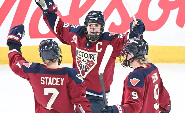 Montreal Victoire's Marie-Philip Poulin (29) celebrates with teammates Laura Stacey (7) and Kati Tabin (9) after scoring against the Minnesota Frost during overtime in a PWHL hockey game in Laval, Quebec, Sunday, Jan. 4, 2026. (Graham Hughes/The Canadian Press via AP)
