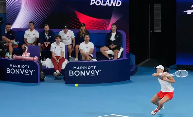 Iga Swiatek of Poland hits a forehand to Belinda Bencic of Switzerland during their final match at the United Cup tennis tournament in Sydney, Sunday, Jan. 11, 2026. (AP Photo/Rick Rycroft)