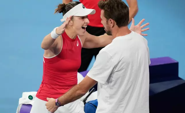 Belinda Bencic of Switzerland, left, celebrates with teammate Stan Wawrinka after defeting Iga Swiatek of Poland in their final match at the United Cup tennis tournament in Sydney, Sunday, Jan. 11, 2026. (AP Photo/Rick Rycroft)