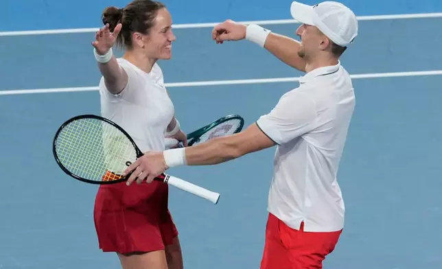 Katarzyna Kawa, left, and Jan Zielinski of Poland celebrate after defeating Belinda Bencic and Jakub Paul of Switzerland in the doubles final match at the United Cup tennis tournament in Sydney, Sunday, Jan. 11, 2026. (AP Photo/Rick Rycroft)
